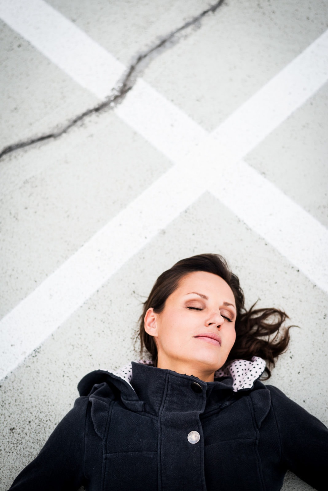 Frau liegt auf dem Asphalt