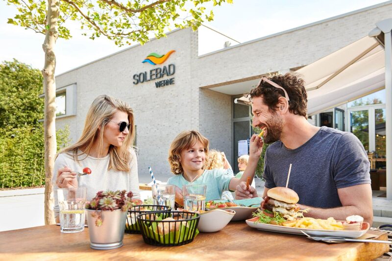 Motiv für die Werbekampagne des Solebad Werne mit einer fröhlichen Model-Familie vor dem Schwimmbad