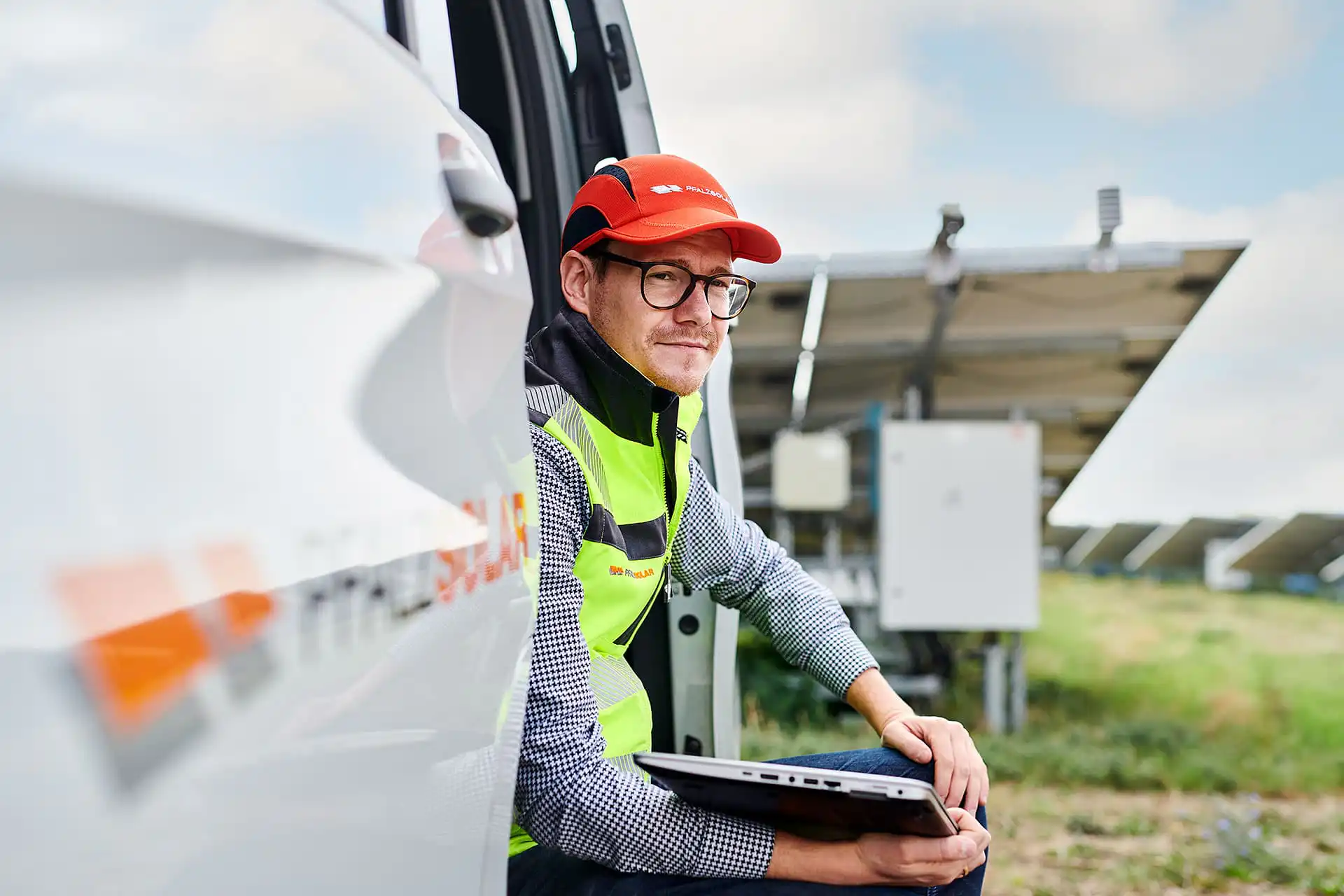 Mitarbeiter sitzt in der offenen Tür eines Fahrzeugs und wartet auf seinen einsatz