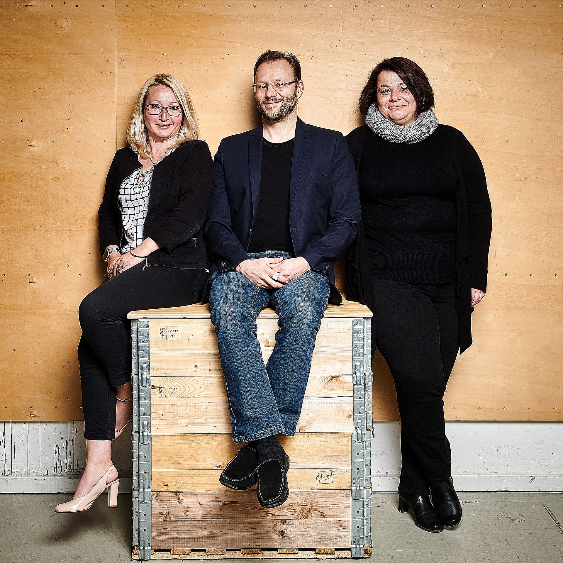 Teilnehmer des Events Greenhouse Ruhr stehend vor einer Holzwand und posieren für Corporate Portraits für die Wirtschaftsförderung Dortmund in einem kleinen Fotostudio on Location