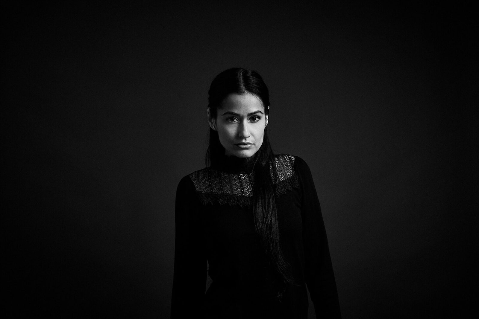 Intensives Schwarzweiß Portrait der Schauspielerin Jenny Piatras in einem Fotostudio vor schwarzem Hintergrund