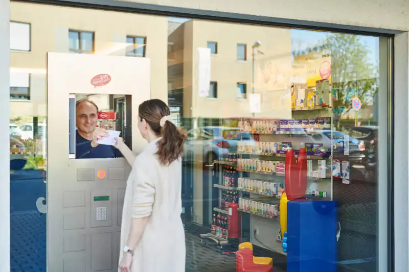 Frau an einer Servicestation in einer modernen Apotheke, professionelle Werbefotografie eines Unternehmens in Witten.