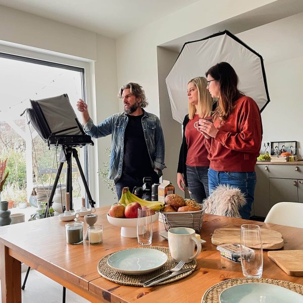 Inszenierte Werbefotografie on Location. Der Fotograf bespricht mit den Kunden die Ergebnisse am Computer
